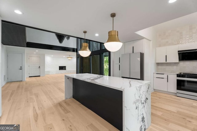 5020 Vallo Vista Ct, Atlanta, GA 30342 - kitchen featuring freestanding refrigerator, gas stove, black microwave, and light wood-type flooring