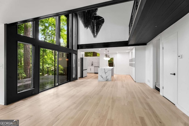 5020 Vallo Vista Ct, Atlanta, GA 30342 - unfurnished living room featuring light wood finished floors and a towering ceiling