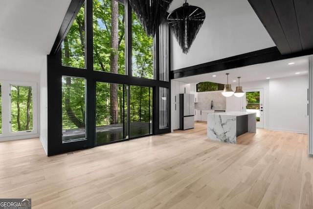 5020 Vallo Vista Ct, Atlanta, GA 30342 - unfurnished living room with light wood-style floors, plenty of natural light, and a towering ceiling