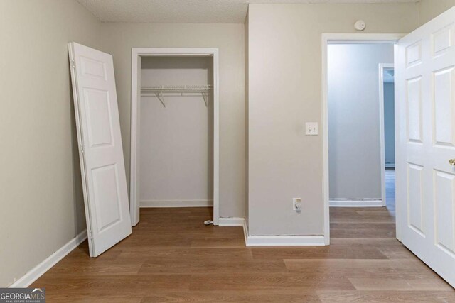 67 Jennifer Ln, Rydal, GA 30171 - unfurnished bedroom with baseboards, a closet, and wood finished floors