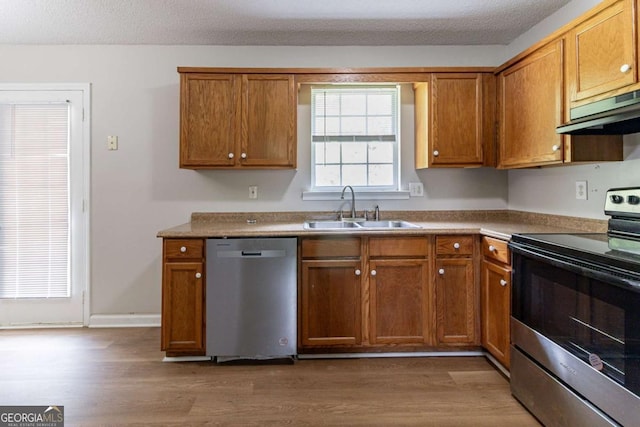 67 Jennifer Ln, Rydal, GA 30171 - kitchen with appliances with stainless steel finishes, under cabinet range hood, wood finished floors, and brown cabinets