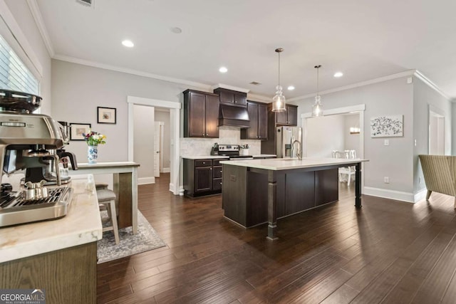kitchen featuring dark brown cabinets, light countertops, extractor fan, stainless steel appliances, and a center island with sink