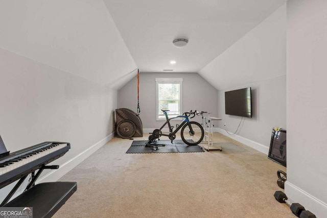 exercise area featuring baseboards, vaulted ceiling, and carpet