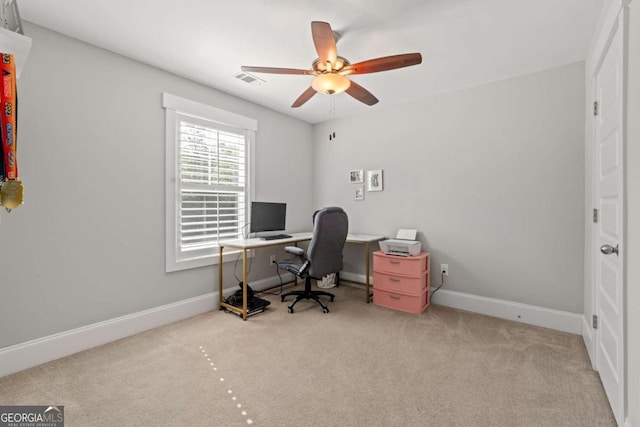 carpeted office space featuring a ceiling fan, baseboards, and visible vents