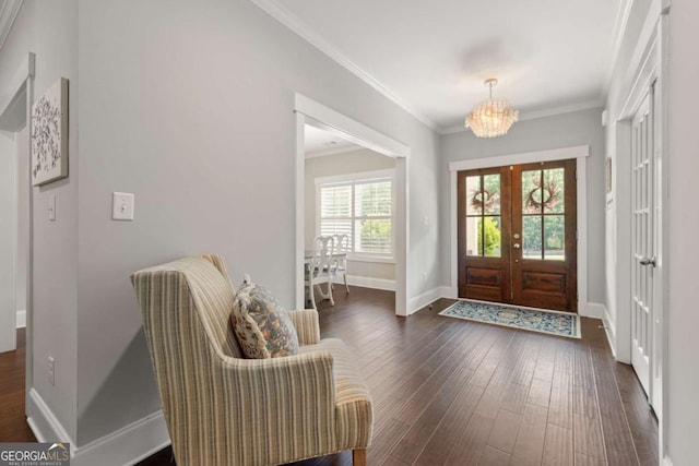 entrance foyer with french doors, baseboards, dark wood-style floors, a notable chandelier, and ornamental molding