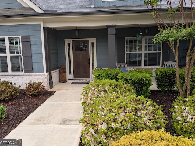 1202 Shiva Blvd, Winder, GA 30680 - doorway to property featuring covered porch, brick siding, and roof with shingles