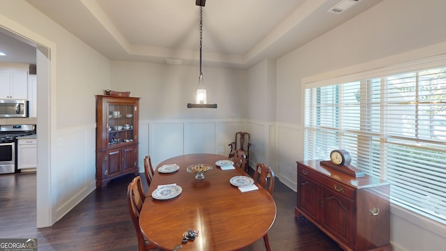 1202 Shiva Blvd, Winder, GA 30680 - dining room featuring dark wood-style flooring, wainscoting, a tray ceiling, and a decorative wall