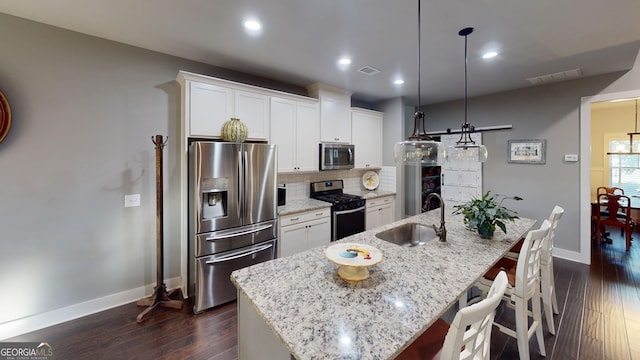 1202 Shiva Blvd, Winder, GA 30680 - kitchen with stainless steel appliances, a sink, baseboards, an island with sink, and dark wood finished floors