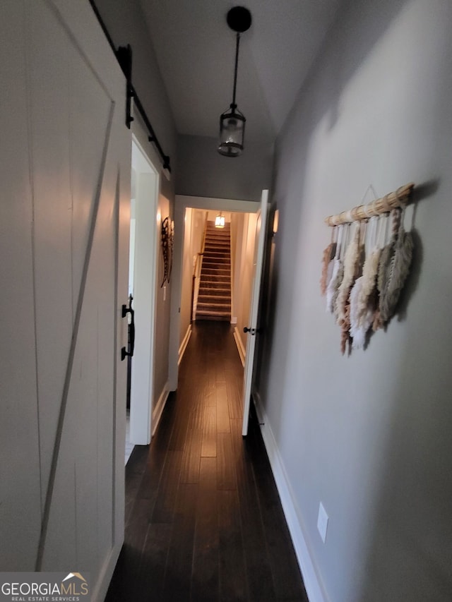1202 Shiva Blvd, Winder, GA 30680 - corridor with a barn door, dark wood-style flooring, stairs, baseboards, and vaulted ceiling