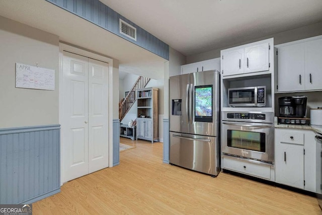 kitchen with visible vents, appliances with stainless steel finishes, white cabinets, and light wood-type flooring