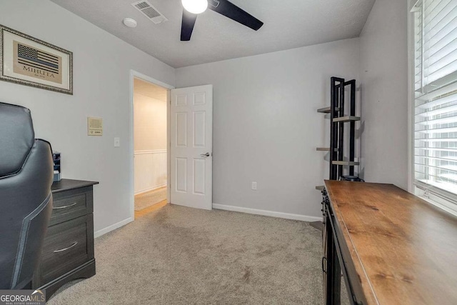home office with ceiling fan, visible vents, baseboards, and carpet
