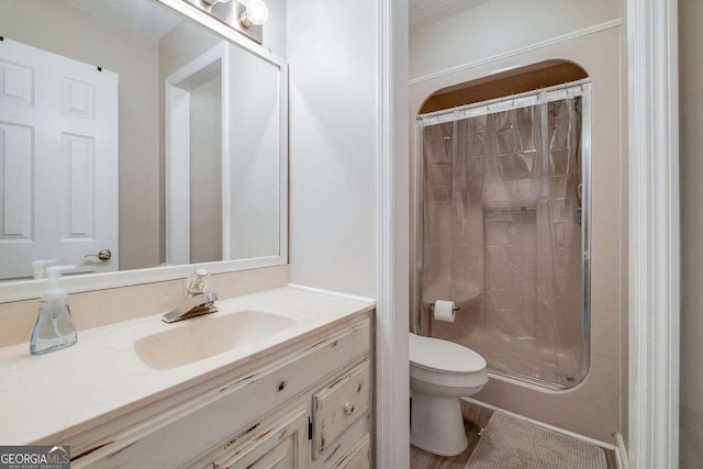 bathroom featuring vanity, a shower stall, and toilet