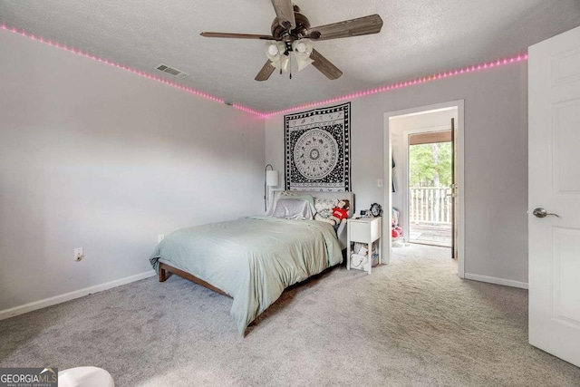 bedroom featuring a ceiling fan, a textured ceiling, visible vents, baseboards, and carpet