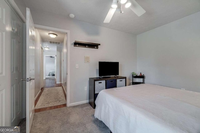 carpeted bedroom featuring baseboards, visible vents, and ceiling fan