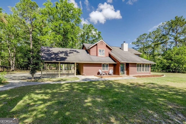 view of front of house with a chimney and a front lawn