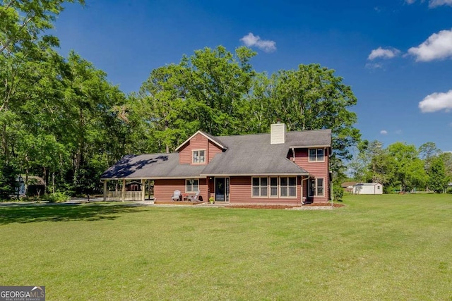 back of property featuring a gazebo, a chimney, and a yard