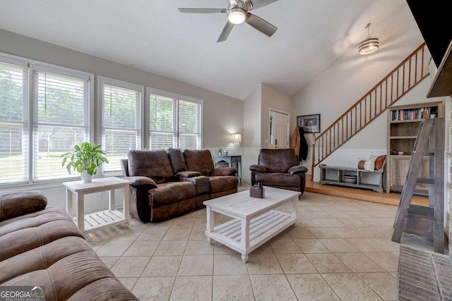 living room featuring a healthy amount of sunlight, high vaulted ceiling, stairway, and a ceiling fan