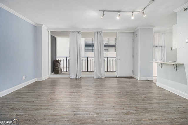 620 Peachtree St NE Unit 601, Atlanta, GA 30308 - unfurnished living room featuring crown molding, baseboards, wood finished floors, and rail lighting