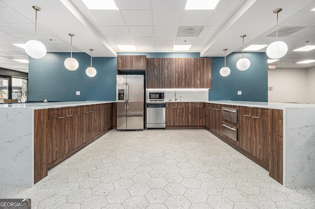 620 Peachtree St NE Unit 601, Atlanta, GA 30308 - kitchen featuring a peninsula, a drop ceiling, light countertops, a warming drawer, and stainless steel appliances