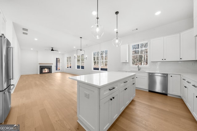 kitchen with recessed lighting, appliances with stainless steel finishes, a sink, and light wood finished floors