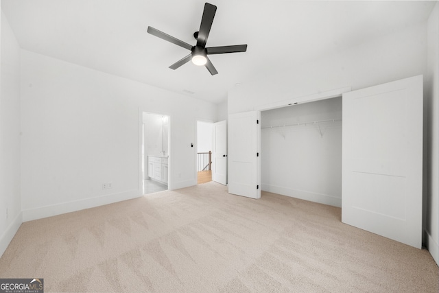 unfurnished bedroom featuring a closet, a ceiling fan, baseboards, ensuite bathroom, and carpet flooring