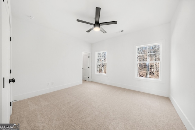 unfurnished bedroom featuring carpet floors, baseboards, a ceiling fan, and visible vents