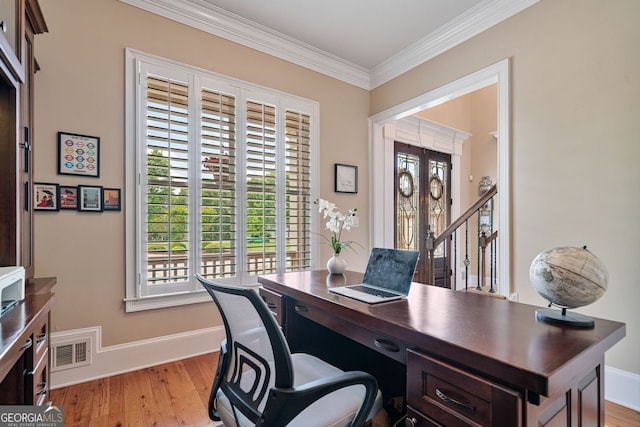 office space featuring visible vents, ornamental molding, baseboards, and light wood-type flooring