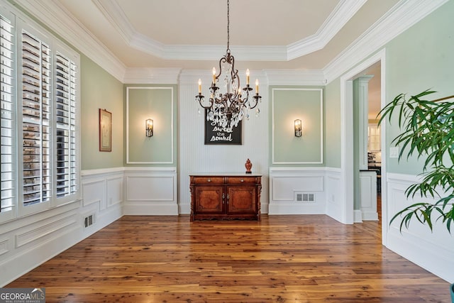 dining space with a healthy amount of sunlight, a decorative wall, and visible vents