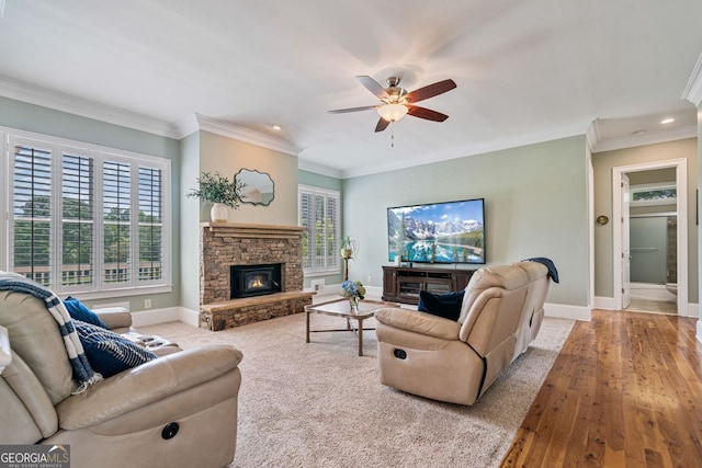 living area with crown molding, ceiling fan, a fireplace, recessed lighting, and baseboards