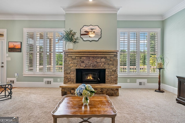carpeted living area featuring visible vents, plenty of natural light, and a stone fireplace