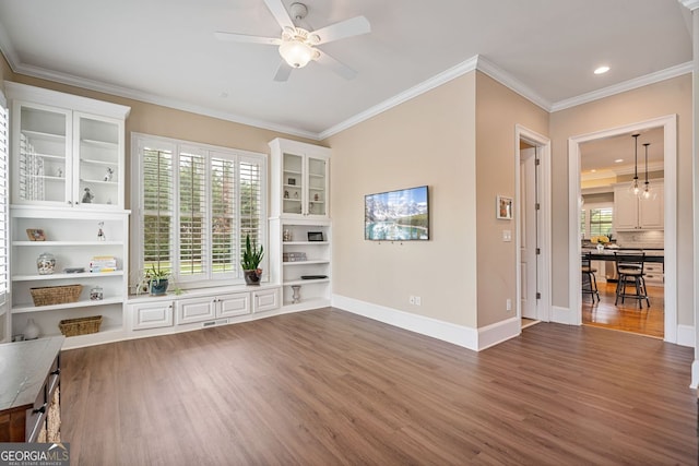 unfurnished living room featuring ceiling fan, visible vents, plenty of natural light, and wood finished floors