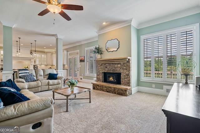 living room featuring ceiling fan, a fireplace, baseboards, carpet, and ornate columns