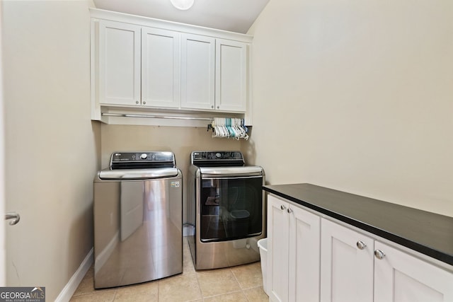 clothes washing area with cabinet space, light tile patterned flooring, baseboards, and washer and dryer