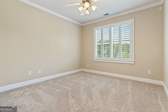 carpeted empty room featuring crown molding, baseboards, visible vents, and ceiling fan