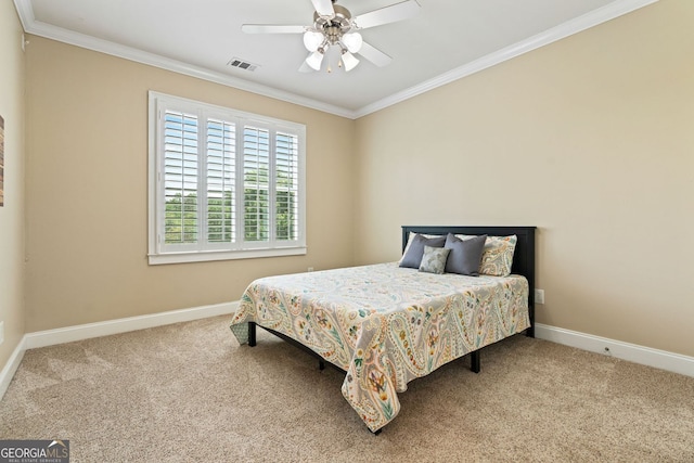 carpeted bedroom featuring visible vents, baseboards, and crown molding