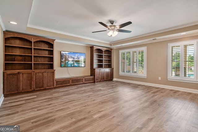 unfurnished living room featuring crown molding, a tray ceiling, ceiling fan, and light wood-type flooring