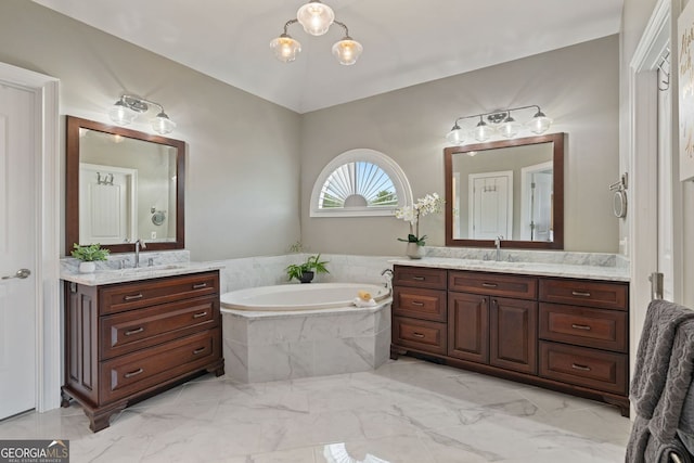 full bathroom with a bath, vaulted ceiling, two vanities, a sink, and marble finish floor
