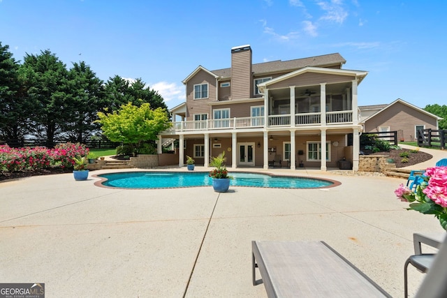 outdoor pool featuring fence, ceiling fan, a sunroom, french doors, and a patio