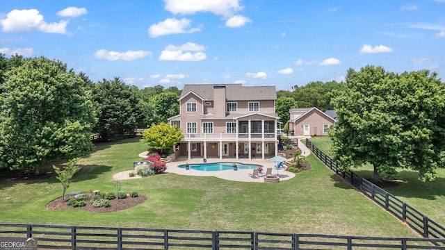 rear view of house featuring a sunroom, a patio area, a fenced in pool, a fenced backyard, and a yard