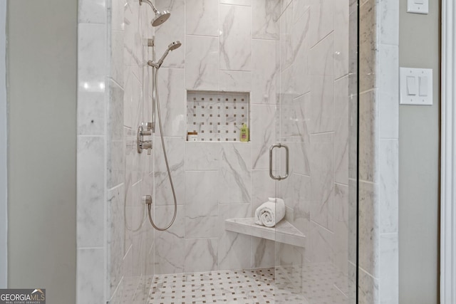 bathroom featuring a marble finish shower