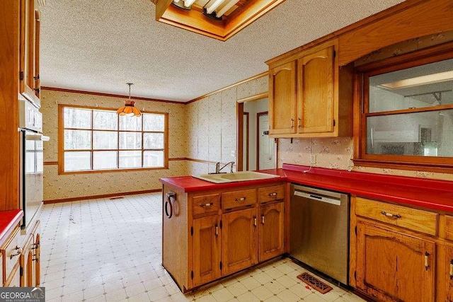 kitchen with crown molding, dark countertops, a sink, dishwasher, and a peninsula