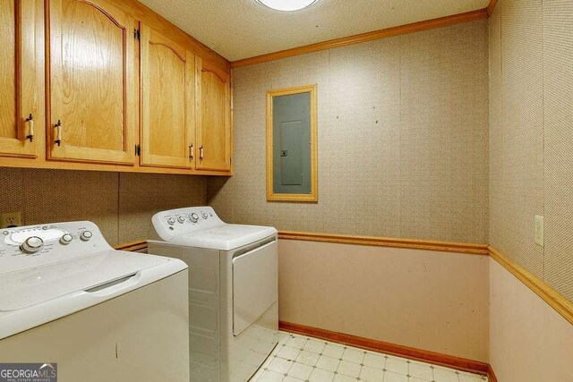 laundry area featuring crown molding, baseboards, electric panel, separate washer and dryer, and cabinet space
