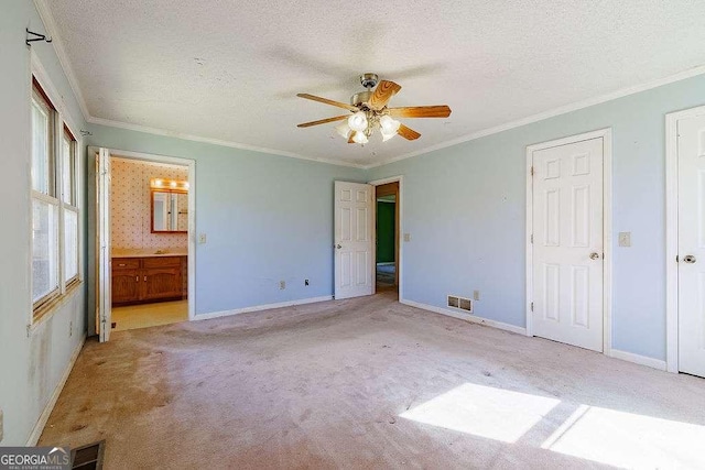 unfurnished bedroom with carpet flooring, a textured ceiling, visible vents, and crown molding