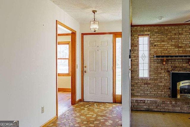 foyer featuring a textured ceiling, baseboards, and plenty of natural light