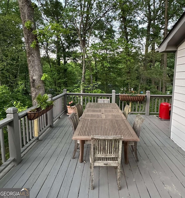 wooden terrace featuring a forest view