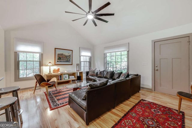 living area featuring a ceiling fan, vaulted ceiling, and light wood finished floors
