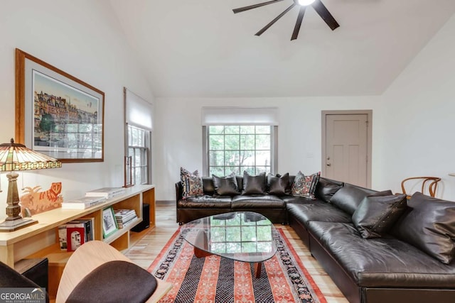 living room featuring a ceiling fan, light wood-type flooring, and lofted ceiling