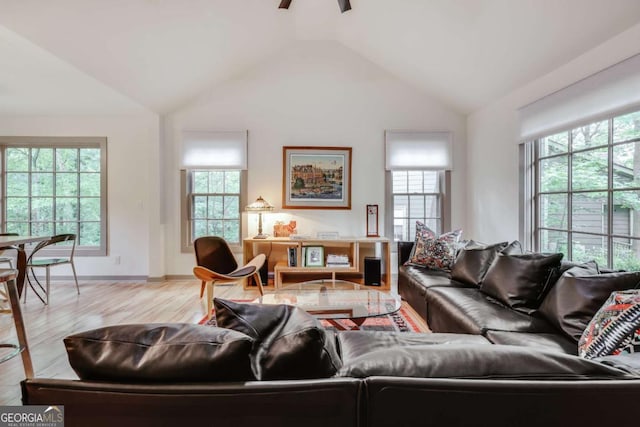 living area with vaulted ceiling, a wealth of natural light, and light wood-style flooring