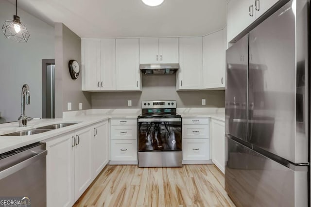 kitchen with a sink, appliances with stainless steel finishes, extractor fan, and light countertops