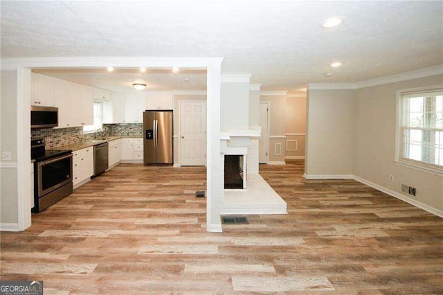1616 W Kellogg Cir, Douglasville, GA 30134 - unfurnished living room with crown molding, visible vents, and light wood-style floors